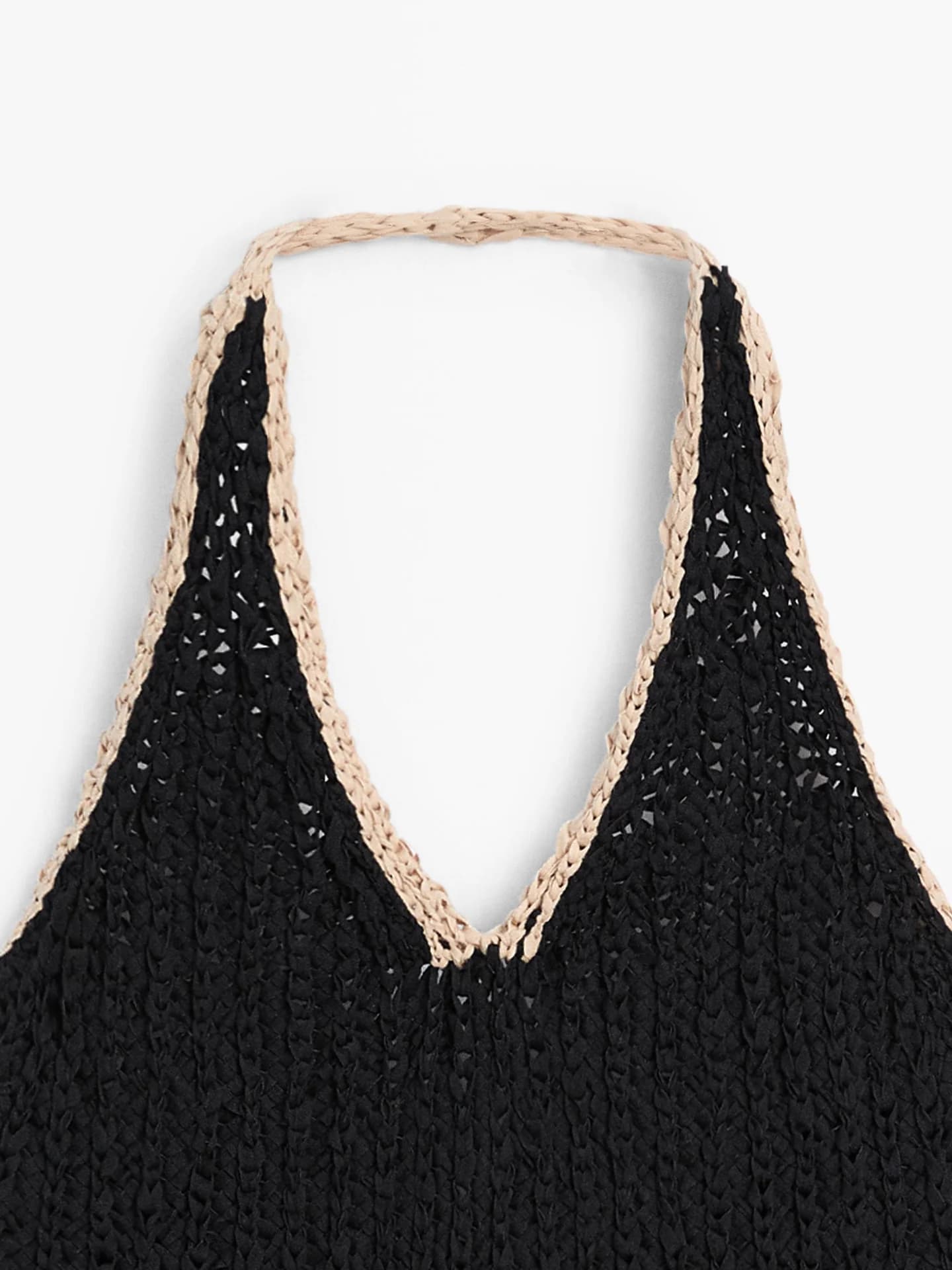 Топ объемной вязки с вырезом через шею и контрастными деталями.